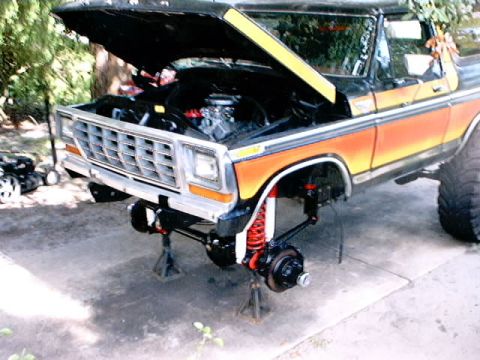 1979 Ford Bronco - This lifted Ford Bronco is undergoing front-end maintenance with its hood open and suspension exposed.