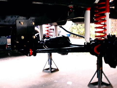 1979 Ford Bronco - Vehicle suspension components, including shocks and springs, are visible while the vehicle is on jack stands.