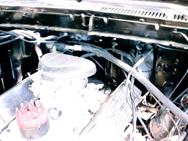 1979 Ford Bronco engine bay with aftermarket air cleaner and red distributor cap
