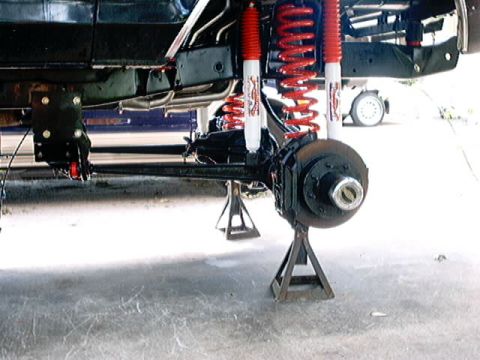 1979 Ford Bronco - Underbody view of a vehicle's suspension system, showing the frame, axle, and brake components.