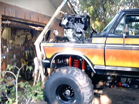 1979 Ford Bronco - This lifted 1979 Ford Bronco is undergoing an engine installation, with the powerplant suspended above the engine bay.