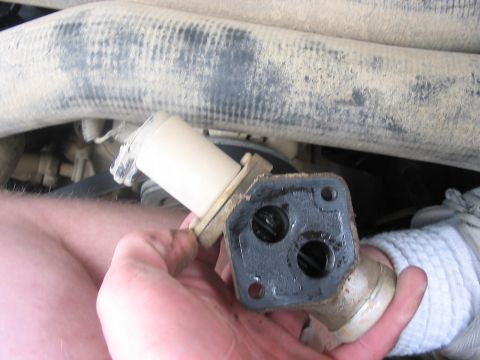 1988 Ford Bronco - Close-up of a dirty automotive part being held by a hand.