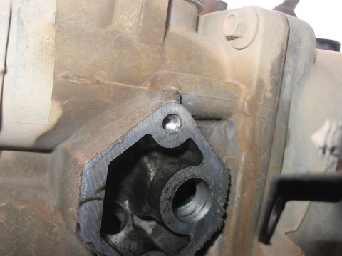 1988 Ford Bronco - This is a close-up view of a metal engine part, likely a housing or adapter, showing mounting holes.