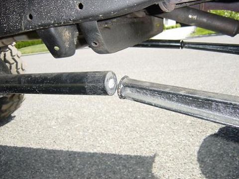 1979 Ford Bronco - Close-up of disconnected suspension linkage bars, likely from an off-road vehicle.