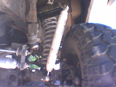 1979 Ford Bronco - Underside view of a vehicle's suspension system, showing the coil spring and shock absorber.
