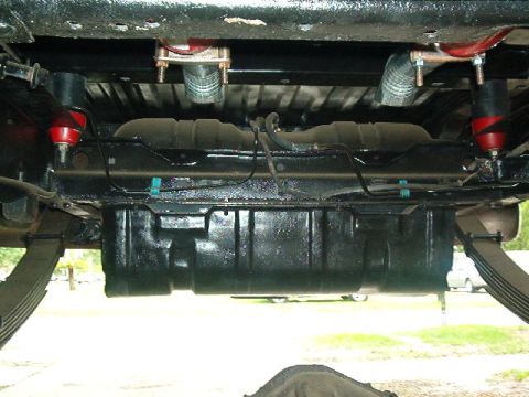 1979 Ford Bronco - Undercarriage view reveals fuel tank, leaf springs, and suspension parts.