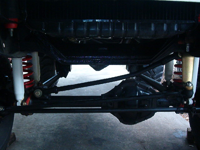 Undercarriage view of a 4x4 vehicle showing suspension components and differential