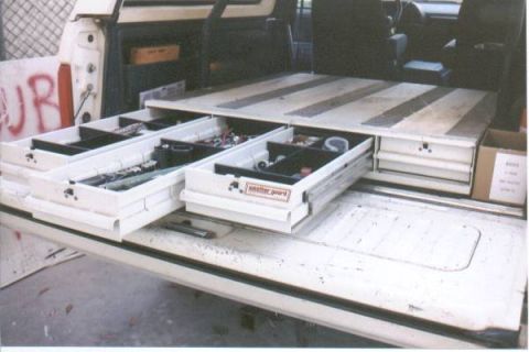 1990 Ford Bronco - The rear of a vehicle is outfitted with custom pull-out drawers for tool and supply organization.