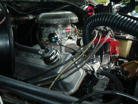 1979 Ford Bronco - Close-up view of a modified engine bay, a prominent carburetor and ignition system.