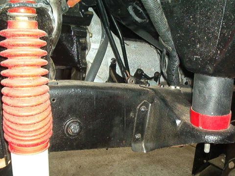 1979 Ford Bronco - Close-up view of a vehicle's undercarriage, showing suspension and frame elements.