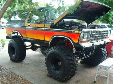 1979 Ford Bronco - This lifted 1979 Ford Bronco features a striking orange-to-yellow gradient paint job and aggressive off-road tires.