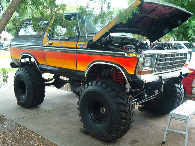 Lifted 1979 Ford Bronco with orange-to-yellow gradient paint and lifted suspension
