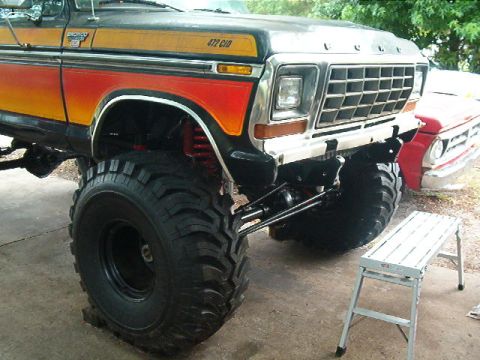 1979 Ford Bronco - This lifted 1979 Ford Bronco features a custom paint job and large off-road tires. A second vehicle is partially visible.