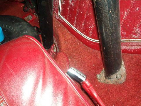 1979 Ford Bronco - Close-up of the interior, showing red upholstery, carpet, and a floor-mounted shifter.