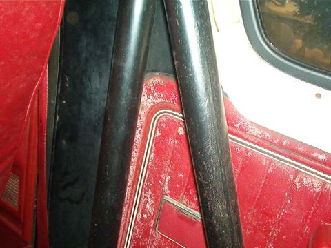 1979 Ford Bronco - Close-up of the interior, focusing on the red upholstery and roll bar structure.