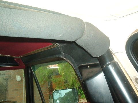 1979 Ford Bronco - Close-up view of the interior trim and headliner of a vehicle, with a side mirror reflecting the outside.