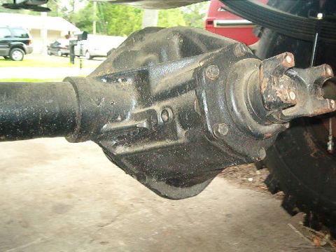 1979 Ford Bronco - A close-up view of a vehicle's rear axle differential and driveshaft, with other vehicles visible in the background.