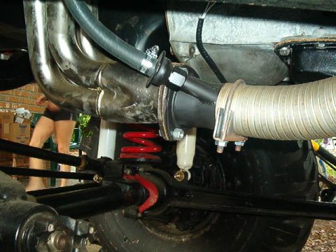 1979 Ford Bronco - Underside view shows exhaust and suspension parts of a vehicle, with a person in the background.
