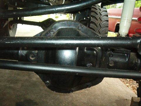 1979 Ford Bronco - Close-up view of a vehicle's rear differential and suspension components, with another vehicle partially visible.
