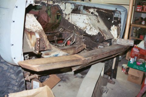 1966 Ford Bronco - This heavily rusted vehicle chassis is undergoing extensive restoration work in a garage setting.