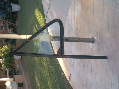 1988 Ford Bronco - A vent window frame is shown, detached from a vehicle and mounted on a pole.