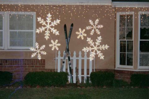 1988 Ford Bronco - Winter decorations including skis and illuminated snowflakes adorn the front of a house.