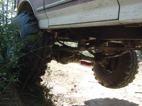 1993 Ford Bronco - Undercarriage view of a lifted 1993 Ford Bronco with aggressive off-road tires.