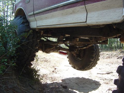 1993 Ford Bronco - Undercarriage view of a 1993 Ford Bronco with lifted suspension and oversized tires.