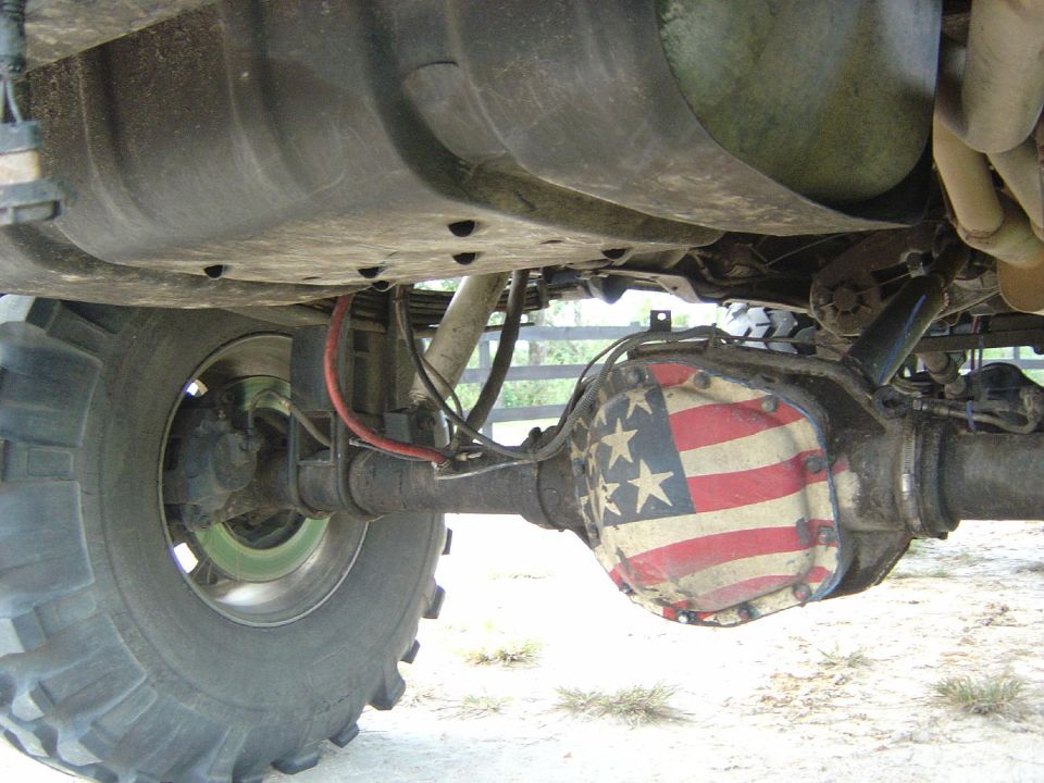 Rear axle differential cover painted with an American flag pattern on a vehicle with large tires