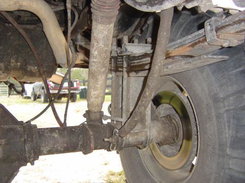1993 Ford Bronco - Close-up of the rear axle and suspension system on a 1993 Ford Bronco, showing leaf springs and a shock absorber.