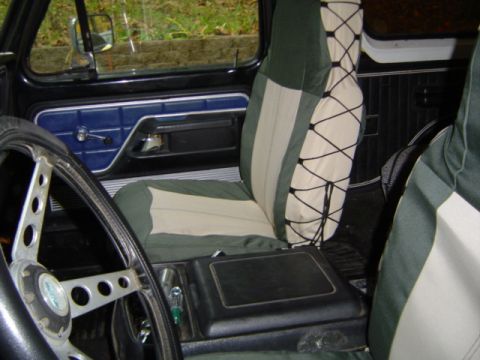 1979 Ford Bronco - The interior of this vehicle features custom seat covers and an aftermarket steering wheel, with a visible watermark from Supermotors.net.