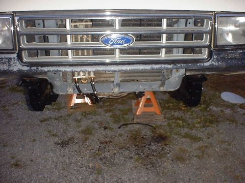 1988 Ford Bronco - The front grille and axle assembly of a 1988 Ford Bronco is shown while supported by jack stands.