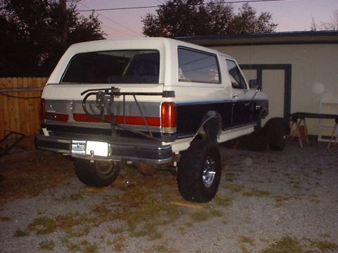 1988 Ford Bronco - This 1987 Ford Bronco is shown from the rear with a two-tone paint scheme and off-road tires.