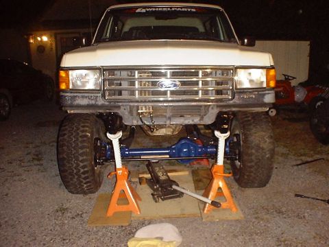 1988 Ford Bronco - Front axle of a 1987 Ford Bronco is removed and supported by jack stands for maintenance.