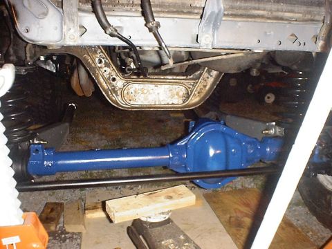 1988 Ford Bronco - Close-up view of a freshly painted blue front axle assembly, likely undergoing restoration or repair.
