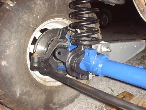 1988 Ford Bronco - Close-up of a vehicle's front axle assembly, showing the differential, suspension, and tire.