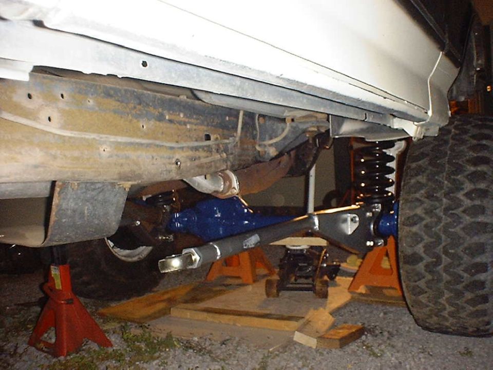 Front axle assembly with blue differential and suspension components on jack stands
