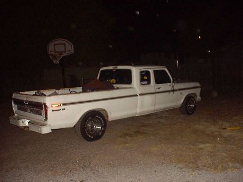 1988 Ford Bronco - White Ford F-Series SuperCab pickup truck parked at night.
