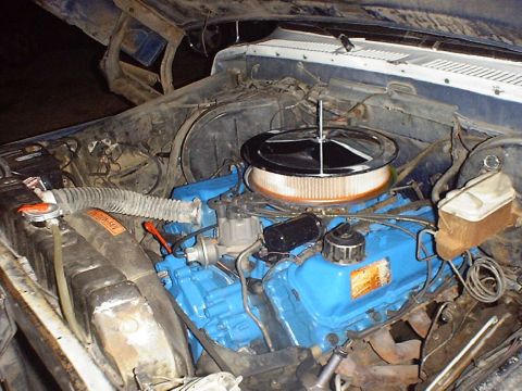 1988 Ford Bronco - The engine bay of a blue 1974 Ford truck, a blue painted engine and chrome air cleaner assembly.
