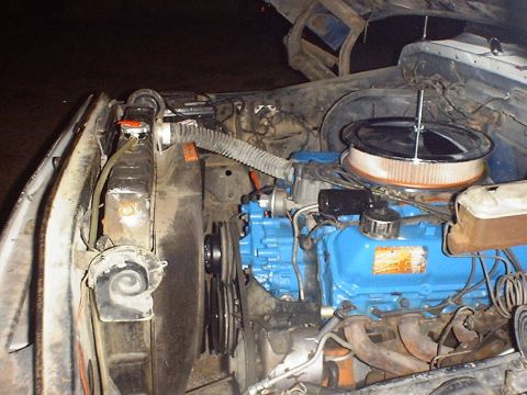 1988 Ford Bronco - Close-up view of a vehicle's engine bay, a blue engine block, air filter assembly, and radiator.