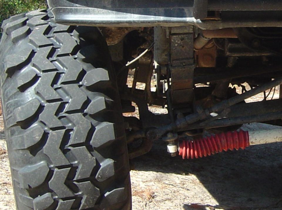 Close-up of a large off-road tire and red shock absorber