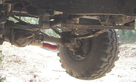 1993 Ford Bronco - The photo shows the undercarriage of a vehicle, focusing on the suspension and a large off-road tire.