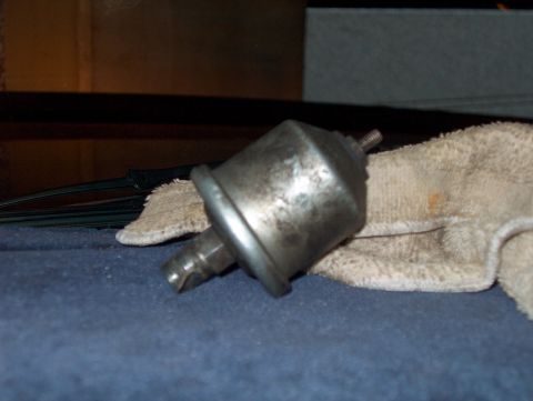 1986 Ford Bronco - Close-up of an unidentified metal automotive part, possibly a sensor or switch.