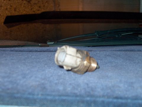 1986 Ford Bronco - A brass automotive sensor with a white plastic connector is visible on the dashboard near the windshield wipers.