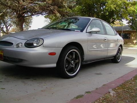 1999 Ford Taurus - A silver 1999 Ford Taurus is shown from a three-quarter front view, parked outdoors.
