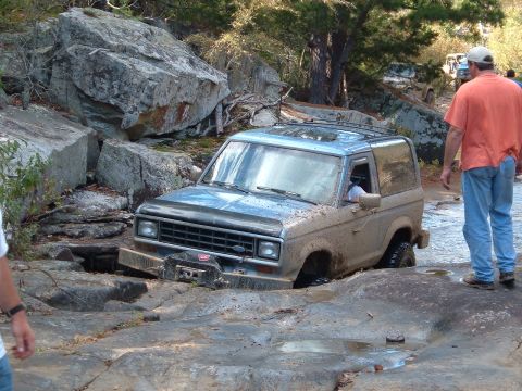 1986 Ford Bronco - Ford Bronco navigating difficult rocky terrain during an off-road excursion.