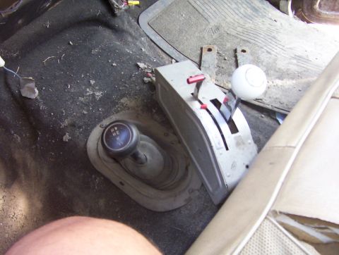 2000 Ford F-450 - The interior of a vehicle shows a manual transmission shifter and a 4x4 transfer case lever with visible markings.
