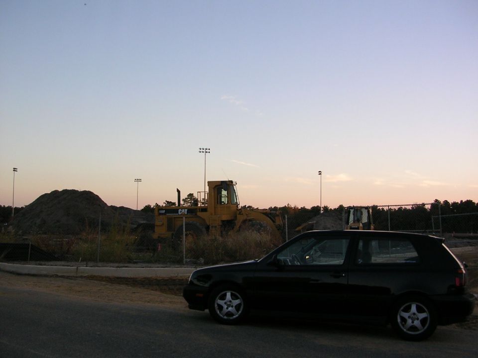 Black 1996 Volkswagen GTI parked on road, construction site in background