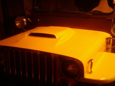 1978 Ford Bronco - Close-up of a yellow Jeep CJ hood a hood scoop and chrome grille.