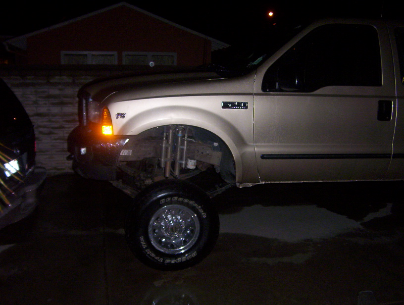 Gold Ford F-450 pickup truck, 3/4 front view, lifted suspension